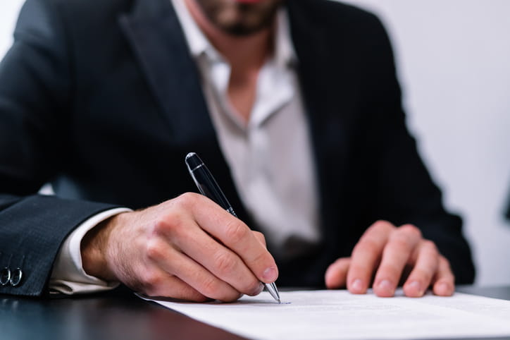 A brain injury lawyer filling out paperwork at his desk.