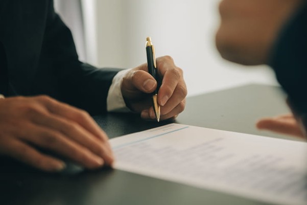 A lawyer fills out paperwork for a client who was in a car accident.